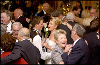 Main image of married couple on dancefloor surrounded by guests.